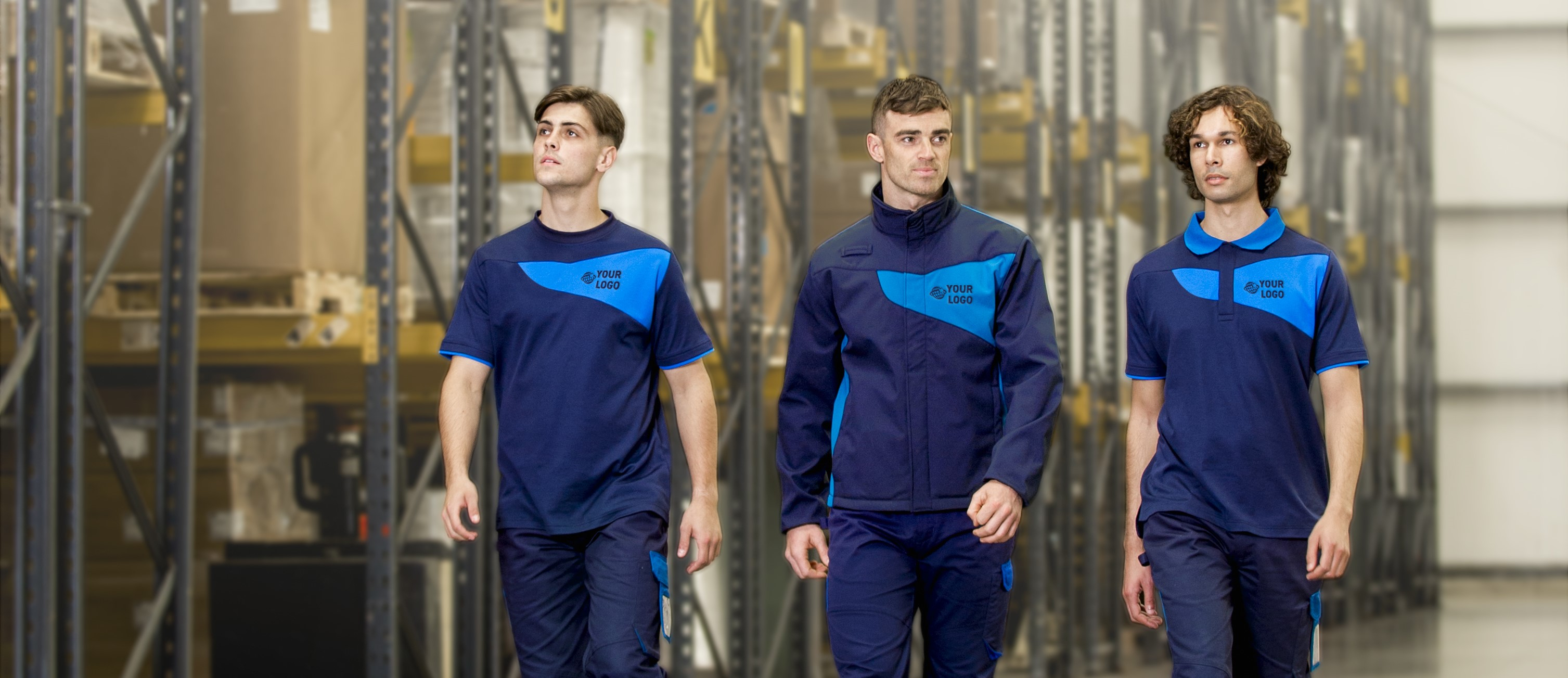 Drie jonge mannen in uniforme werkkleding in verschillende blauwtinten. Op de achtergrond zijn opbergplanken te zien en linksonder in de afbeelding is het logo van de werkkledingfabrikant Portwest te vinden. Er is een link naar de gehele PW2 collectie.