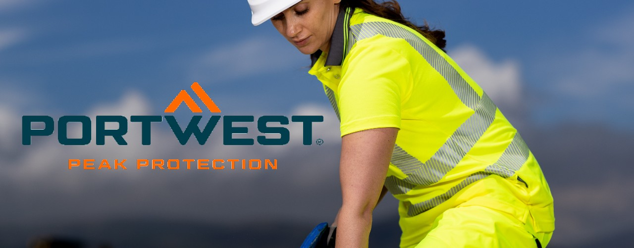 Dame in waarschuwingsgele werkkleding voor een bergdecor met een groot Portwest-logo in oranje en blauw.