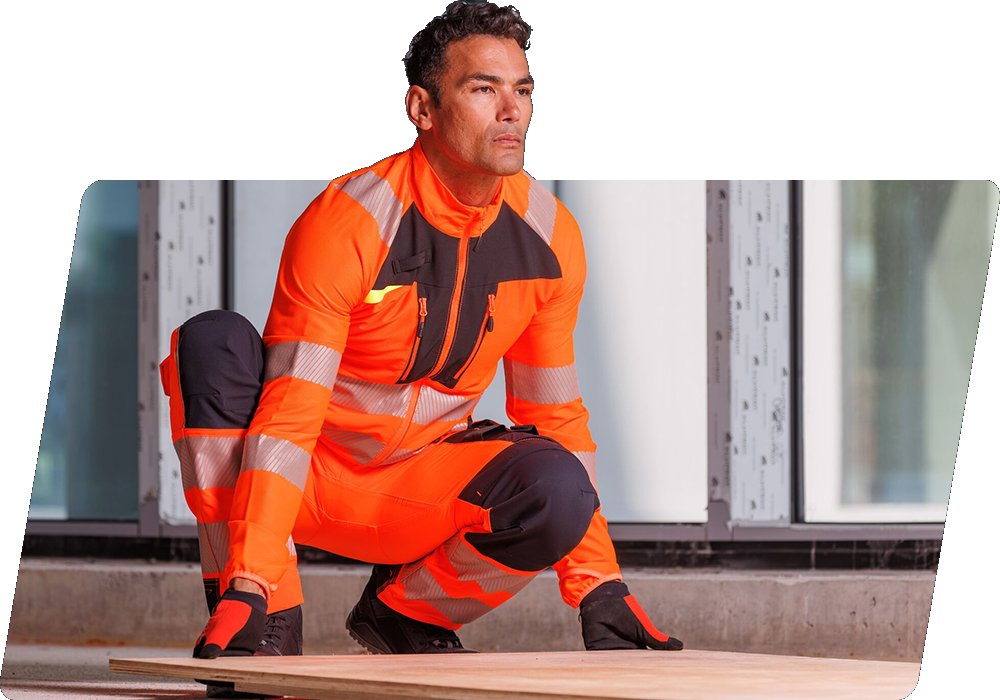 Een donkerharige arbeider in oranje hoge zichtbaarheidskleding tilt een houten paneel van de grond. Er is een link naar onze DX4-collectie.