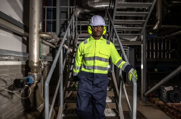 Werknemer in Hi-Vis kleding loopt een trap af