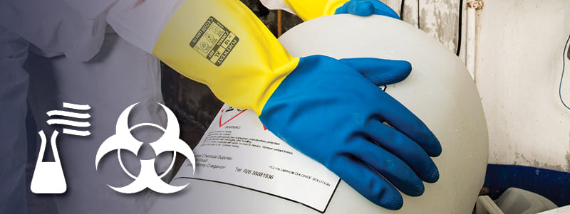 Werknemer met Portwest chemisch bestendige handschoenen die gevaarlijke items hanteren.