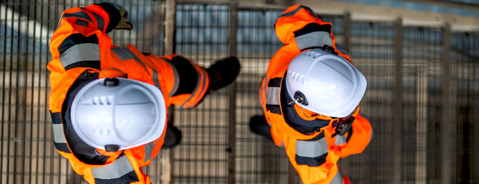 Luchtfoto van bouwvakkers in high-vis kleding.