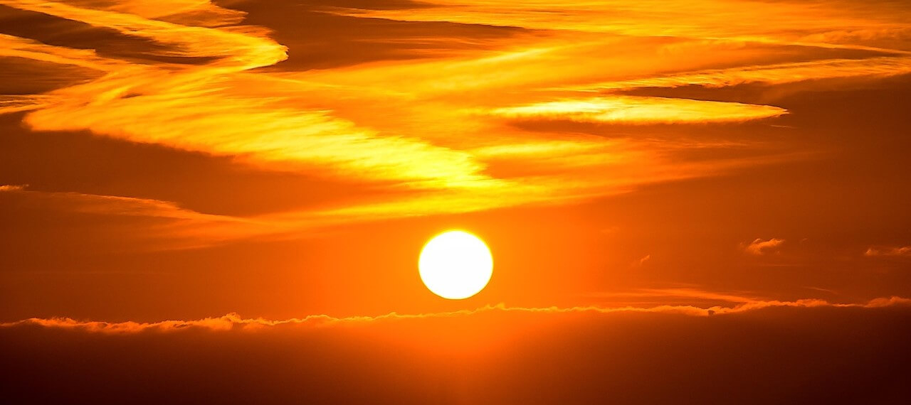 De zon gaat onder tegen een vurige rode hemel en je voelt de hitte bijna letterlijk.